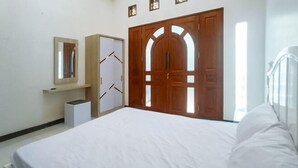 A bedroom with a bed, a wardrobe, a mirror, and a door with a window. - Vj Sweethome Syariah Near GOR Turida (Turida)