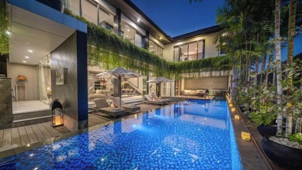 A modern pool area with a glass bottom, surrounded by a wooden deck and lounge chairs. - Villa Balimu Seminyak (Bali)