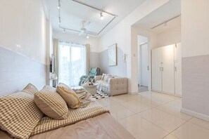 Een moderne hotelkamer met een bed, een zithoek, een eethoek en uitzicht op de stad.