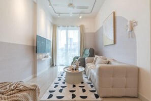 Un salon moderne avec un canapé, une table basse et un téléviseur.