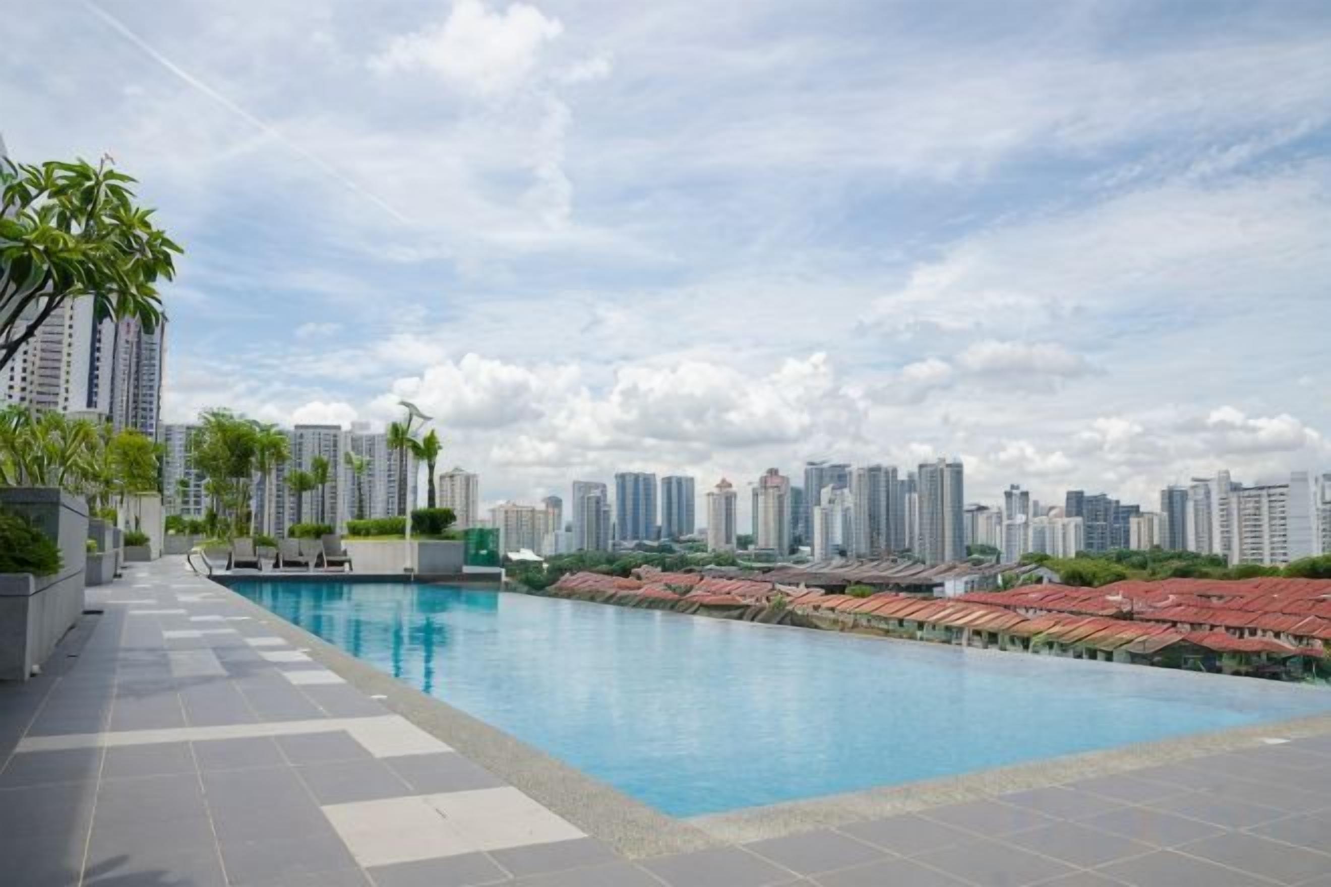 A swimming pool with a cityscape view, surrounded by high-rise buildings.