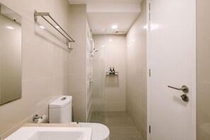 Een badkamer met een bad, toilet en douche.