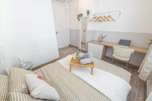 A hotel room with a bed, a desk with a laptop, a chair, and a small table with towels. - SURIA NORTH KIARA BY FEEL HOME (Kuala Lumpur)