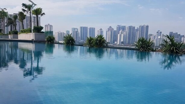 En swimmingpool med stadens silhuett som bakgrund.