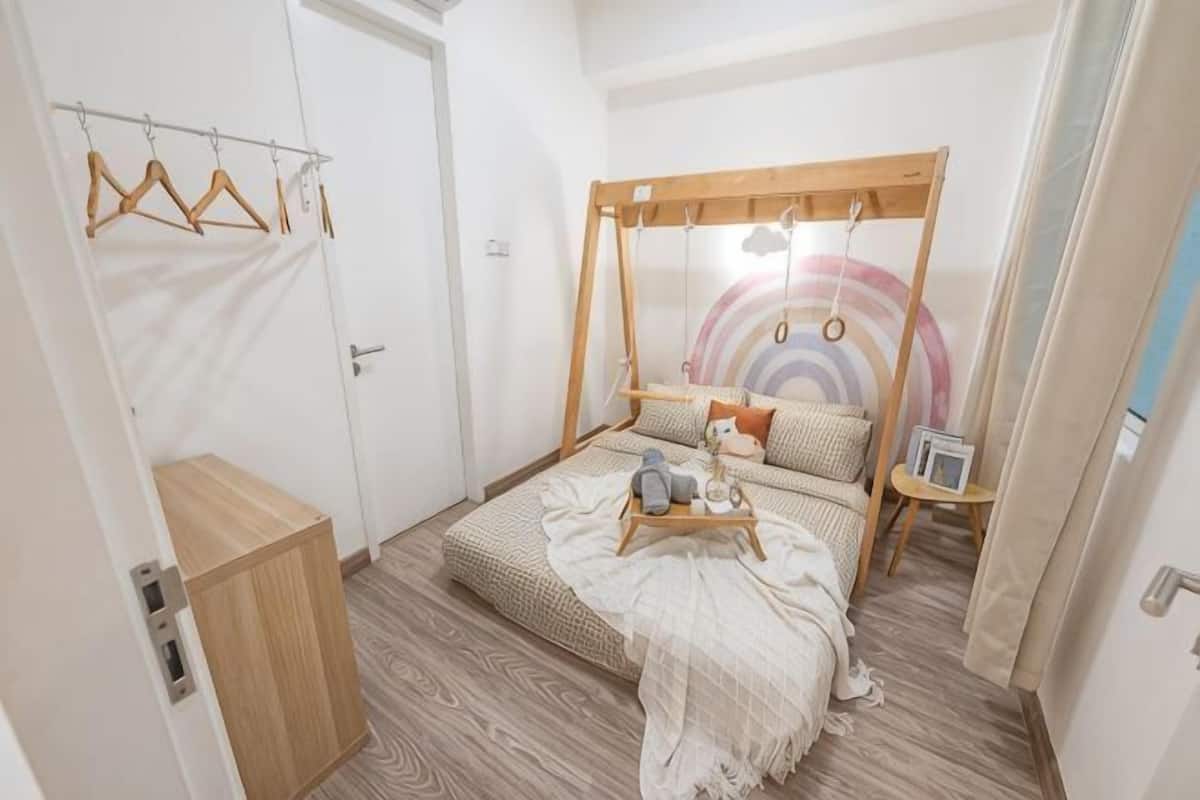 Een slaapkamer met een bed, een houten kledingkast, een kledingroede en een muur met een rond ontwerp.