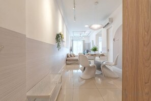 Un intérieur moderne comprenant un coin repas, un canapé et une plante.