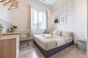 Une chambre à coucher moderne avec un lit, une table de chevet et une fenêtre.