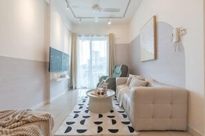 Un salon moderne avec un canapé, une table basse et un téléviseur.