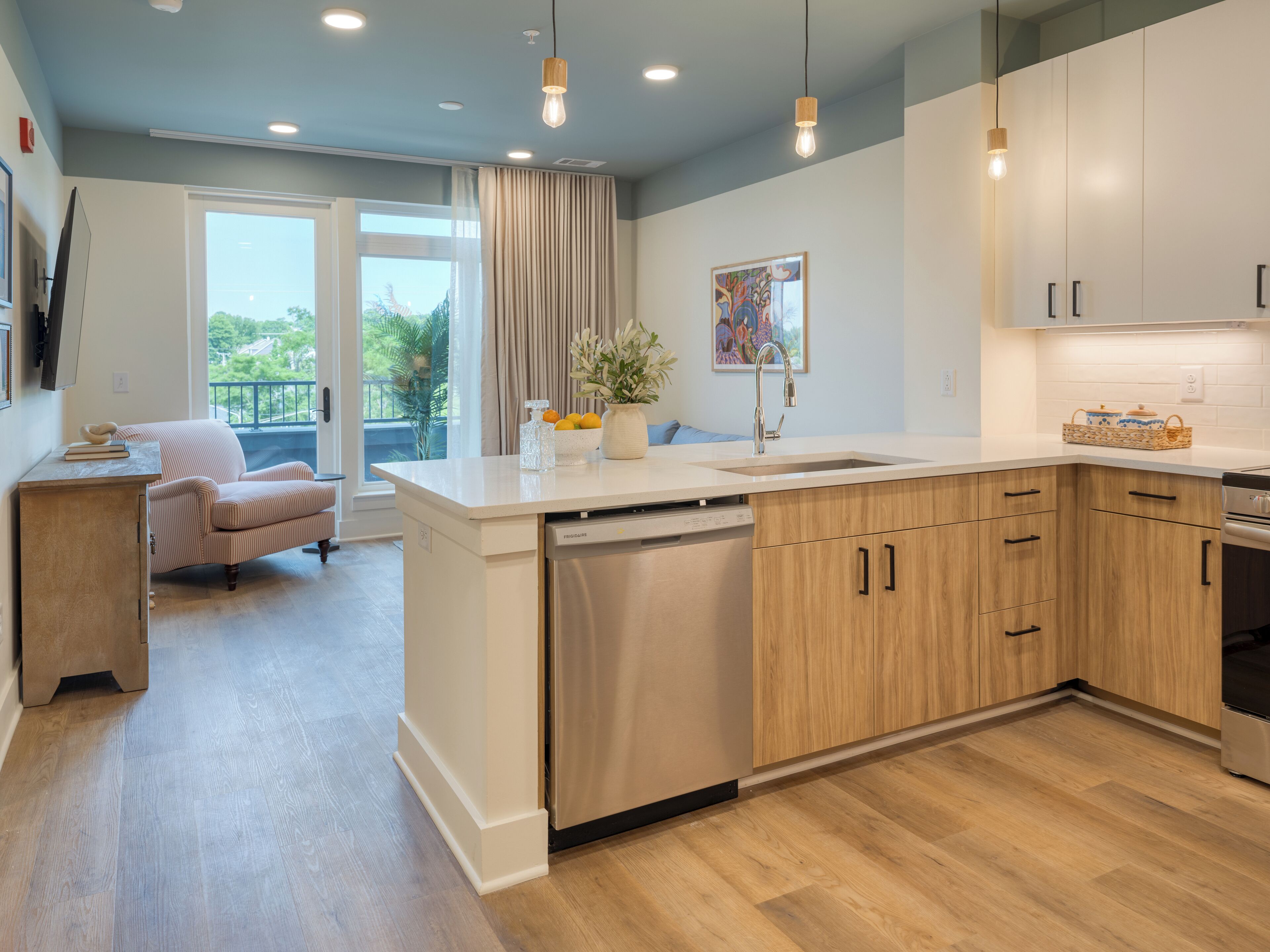 Een moderne keuken met houten kastjes, een vaatwasser en een groot eiland.