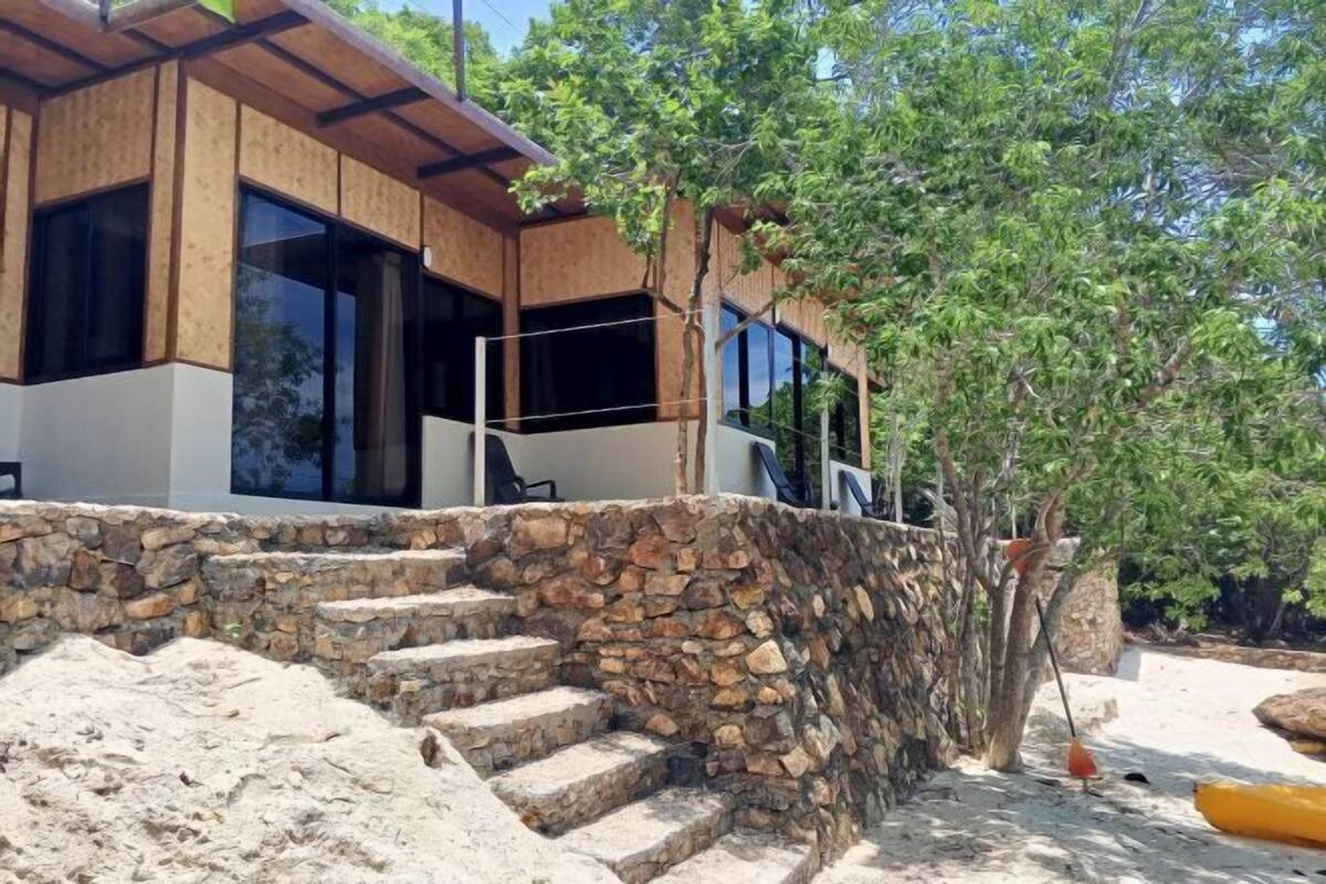 A modern building with a stone staircase leading to a wooden deck.