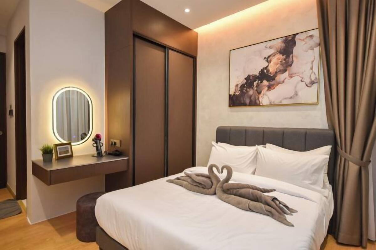 Quarto de hotel com cama, mesa de cabeceira com espelho, quadro na parede e cortina.