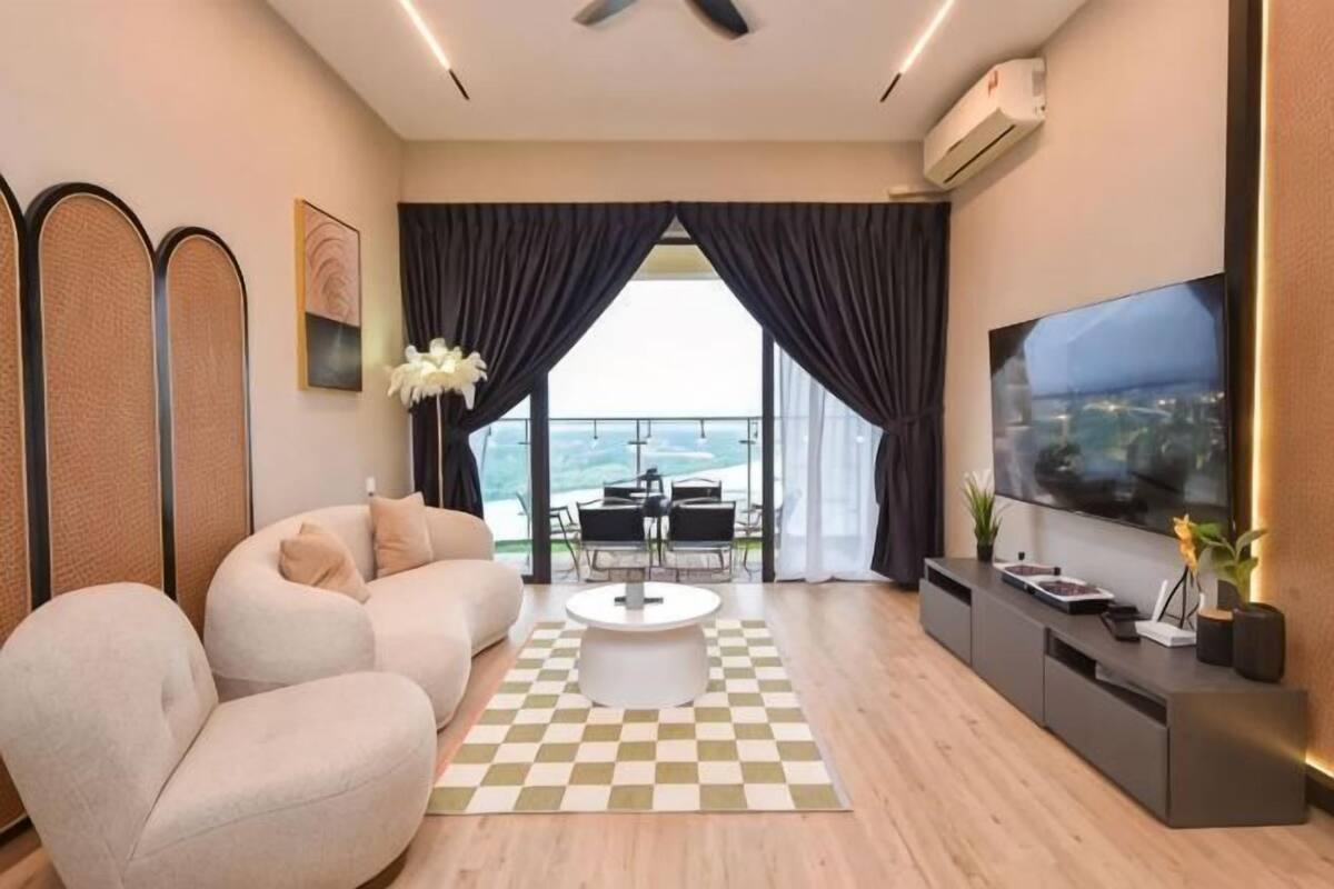 Uma sala de estar moderna com sofá, mesa de centro, televisão e varanda com vista.