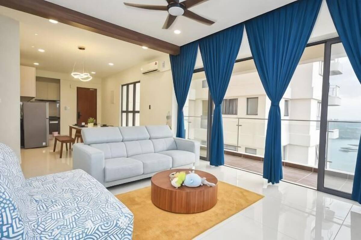 Uma sala de estar moderna com um sofá, uma mesa de centro e uma varanda com vista.