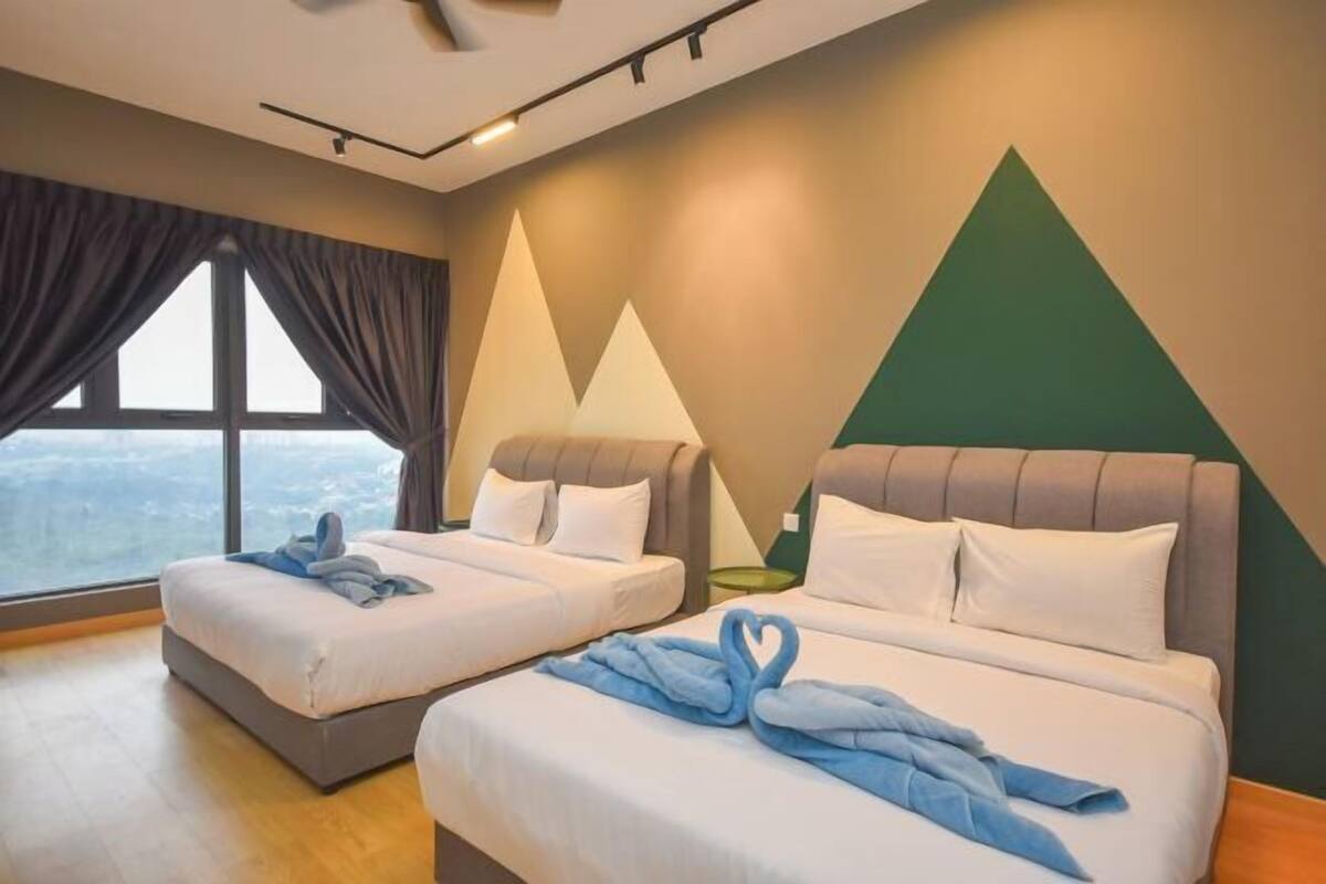 Quarto de hotel com duas camas, uma janela grande e vista para a cidade.