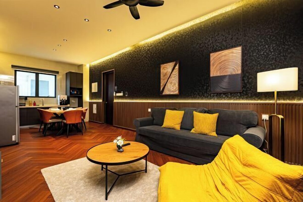 A modern living room with a sofa, coffee table, and a dining area with chairs.