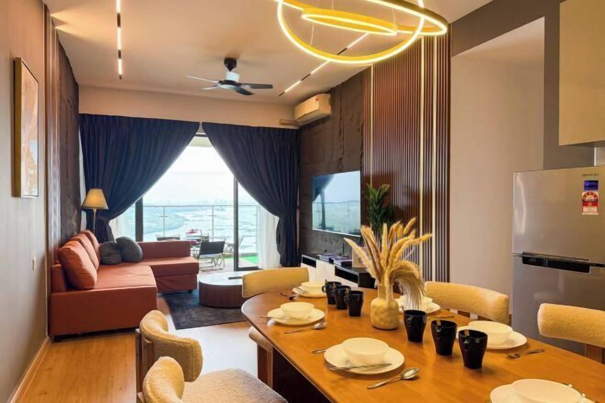 Quarto de hotel moderno com área de refeições, sofá e vista para a cidade.