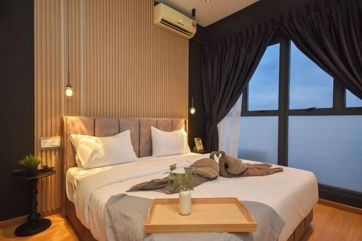 Uma cama bem arrumada com cabeceira de madeira, mesa de cabeceira com uma planta e janela com cortinas.