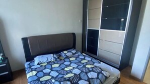 Une chambre à coucher avec un lit, une table de chevet, une armoire et une fenêtre.