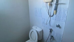 Une salle de bain équipée de toilettes, d’une douche et d’un radiateur fixé au mur.