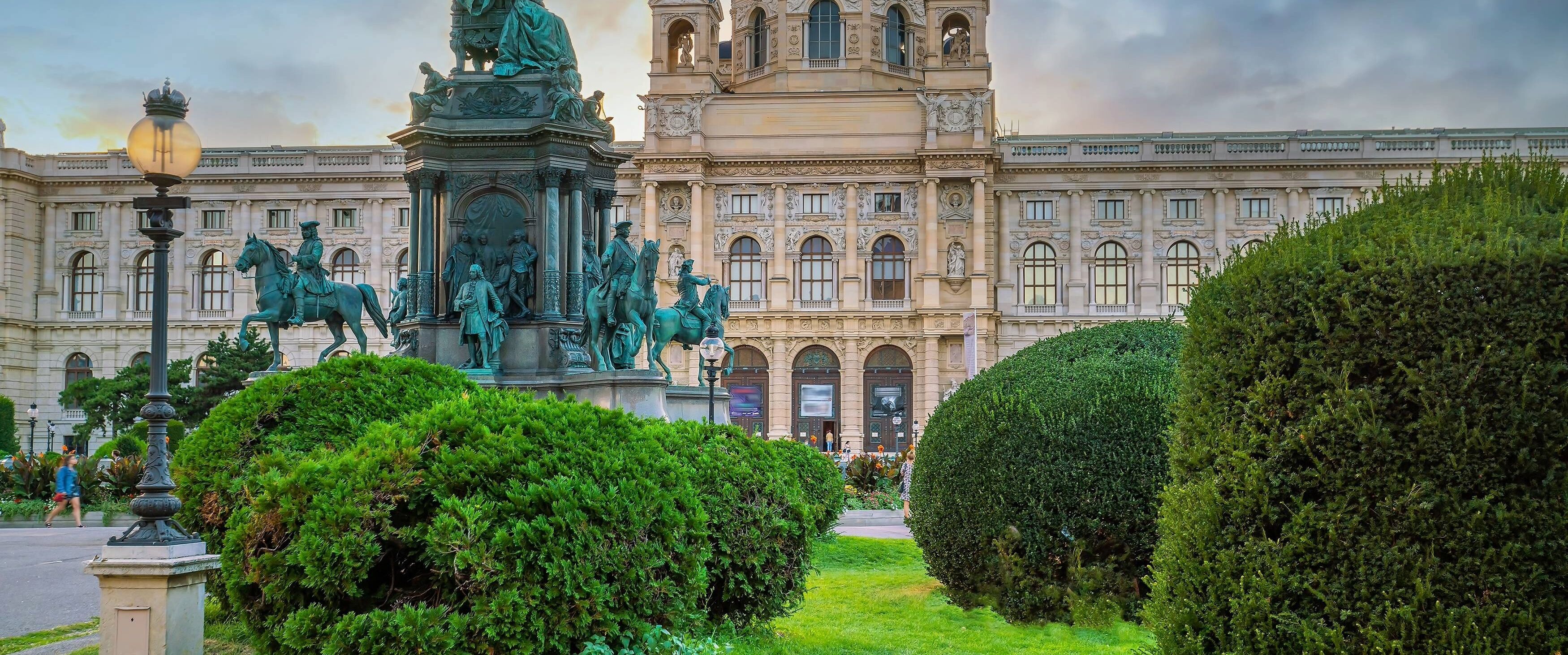 Ein großes Gebäude mit einer Statue eines Mannes zu Pferd davor.
