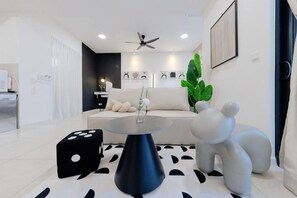 Een moderne woonkamer met een bank, een ronde tafel en een bijzondere fauteuil in de vorm van een olifant.