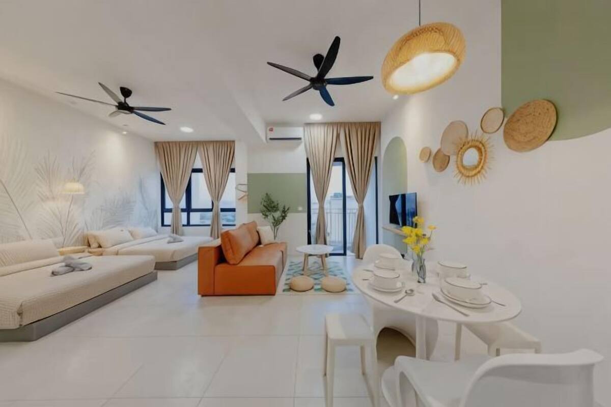 Un salon moderne avec un canapé, une table à manger et des chaises, des ventilateurs de plafond et des œuvres d’art décoratives murales.