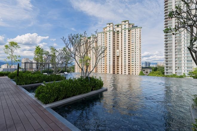 A residential building with a rooftop pool and greenery.