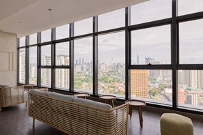 Een modern interieur met grote ramen, een bank en een kleine tafel.