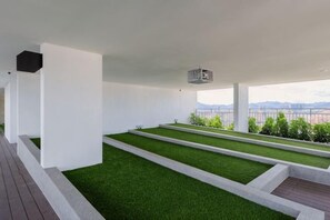 Une terrasse sur le toit, dotée d’un toit plat, d’un écran de projection et offrant une vue sur les montagnes lointaines.