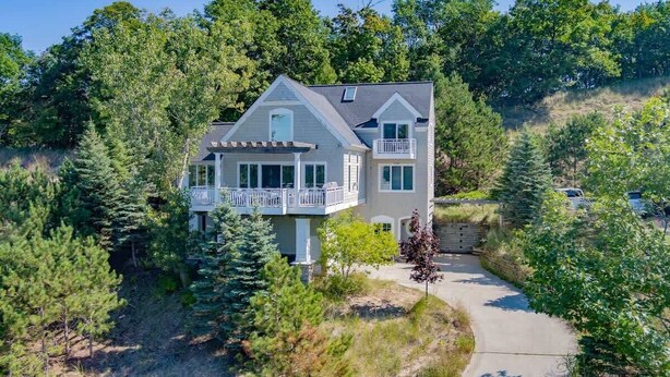 A two-story house with a balcony, surrounded by dense trees and a clear sky. - Viewhouse | Private Beach Access | Walkable | EV (Spring Lake)