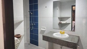 A bathroom with a shower, a sink, and a mirror. - Amorn inn resort (Chiang Rai)