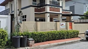 Ένα διώροφο κτίριο με μπαλκόνι στον πάνω όροφο, μια πύλη στην είσοδο και μια επιγραφή στην πρόσοψη.