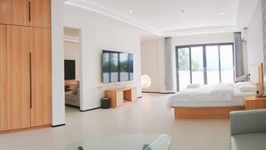 Una habitación de hotel moderna con una cama grande, un televisor y vistas al exterior.