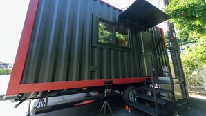 A large metal container with a window, a ladder, and a small step platform. - MAX CUBE Inami Seafront (Inami)