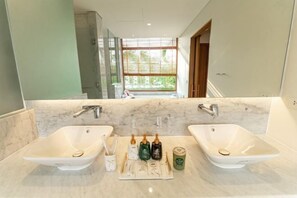 A modern bathroom with two sinks, a large mirror, and a window providing natural light. - Stunning Luxury Villas with Expansive Grounds: An Unforgettable Experience (Da Nang)