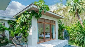 A modern house with a glass door, a small patio, and a pool. - Stunning Luxury Villas with Expansive Grounds: An Unforgettable Experience (Da Nang)