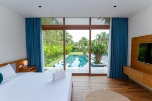 A hotel room with a bed, a TV, a nightstand, and a view of a swimming pool and greenery. - Stunning Luxury Villas with Expansive Grounds: An Unforgettable Experience (Da Nang)