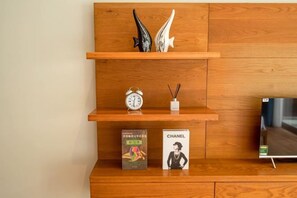 Ein Holzboden mit Dekoration, einer Uhr, einem Buch und einem Fernseher.