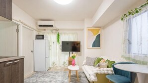 A compact living space with a kitchenette, a sofa, a small round table, and a TV. - Ueno Station 7/2/MAX8/Ginza Asakusa AreaWIFI (Tokyo)