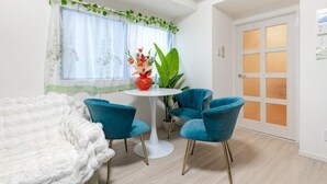 A room with a bed, a round table with chairs, a potted plant, and a door with frosted glass panels. - Ueno Station 7/2/MAX8/Ginza Asakusa AreaWIFI (Tokyo)