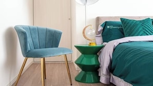 A room with a teal upholstered chair, a green side table with a globe, and a bed with teal bedding and pillows. - Ueno Station 7/2/MAX8/Ginza Asakusa AreaWIFI (Tokyo)