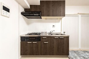 A compact kitchen with a built-in stove, sink, and cabinets. - Ueno Station 7/2/MAX8/Ginza Asakusa AreaWIFI (Tokyo)