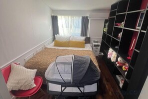 A compact hotel room with a single bed, a small desk, a chair, a crib, and a bookshelf. - Ikebukuro No`3 (Tokyo)
