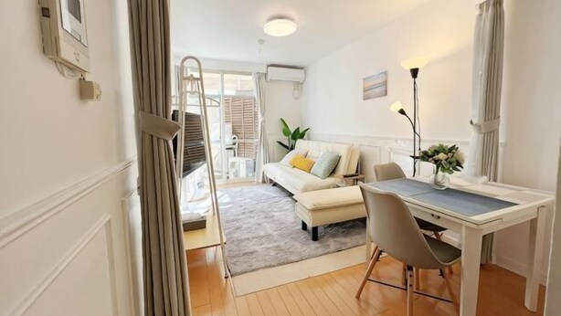 A compact living space with a dining area, a sofa, and a staircase leading to an outdoor area. - Ikebukuro No`3 (Tokyo)