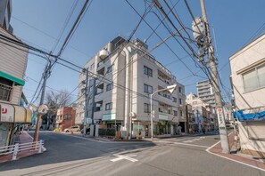 A multi-story building with a flat roof, surrounded by other buildings and overhead power lines. - New/Ueno station 7min walk/Inarimachi station 2min/max 8 people/Ginza Asakusa area (Tokyo)