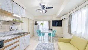 Una cucina moderna con zona pranzo, divano e ventilatore a soffitto.