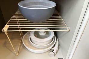 A kitchen with a white metal rack holding a bowl and plates. - Guest House SAKURAYA (Tokyo)