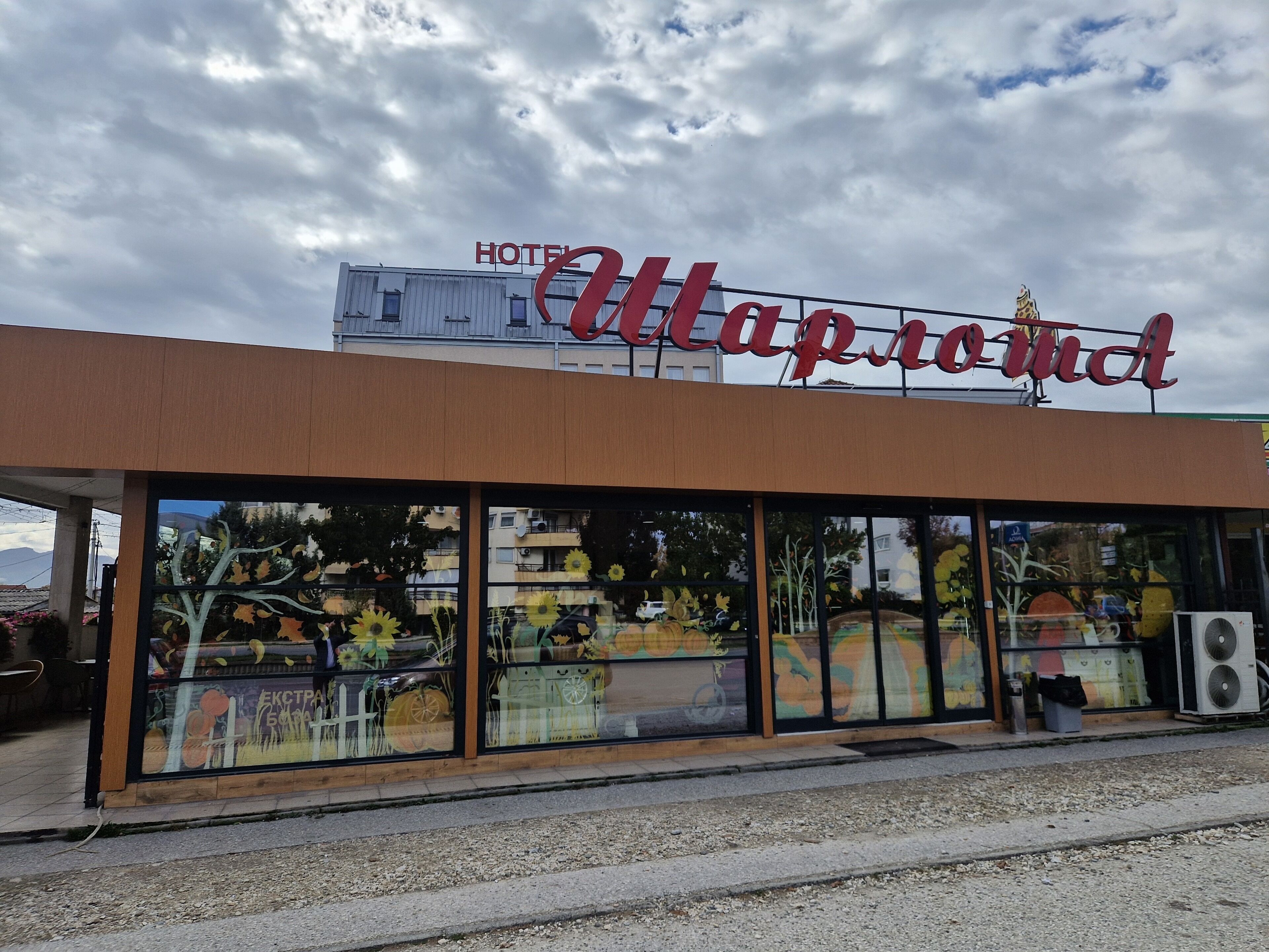 Un hotel llamado "Hotel Map Room" con una fachada moderna y grandes ventanales que exhiben obras de arte.