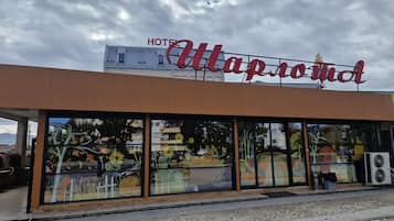 Un hotel llamado "Hotel Map Room" con una fachada moderna y grandes ventanales que exhiben obras de arte.