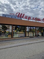 A hotel with a large sign reading "Hotel Map of the World" and large windows displaying autumn-themed decorations.